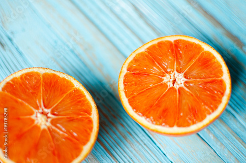 Fototapeta Naklejka Na Ścianę i Meble -  Sliced orange on a blue wooden background