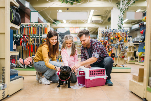 Family buying supplies for little puppy in petshop photo