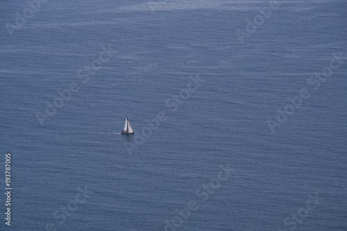 Lonely boat sailing at the open blue sea view from above