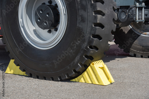 Yellow wheel chocks under the big truck wheels