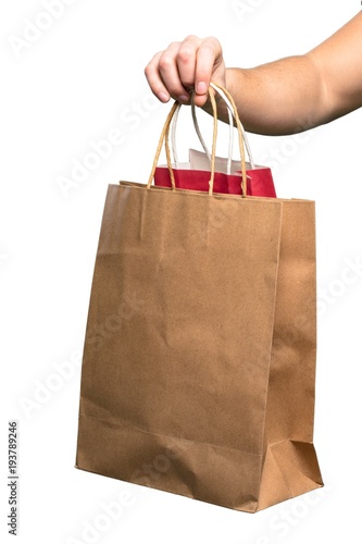 Hand holding Shopping bag over isolated white background