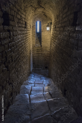 Stone interior with window of an old steeple crypt, located inside an ancient catholic church