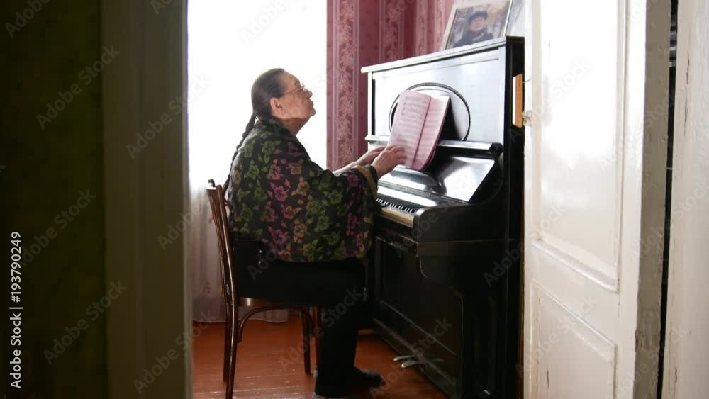 Senior woman at home is playing the piano Senior woman at home is playing the piano