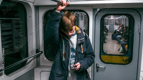 Young boy rides the subway and used smartphone
