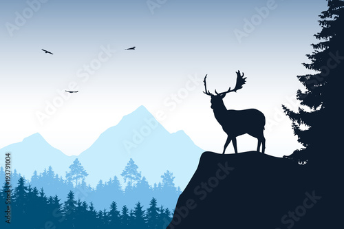 Deer with stags standing at the top of rock with mountains and forest in the background  with flying birds