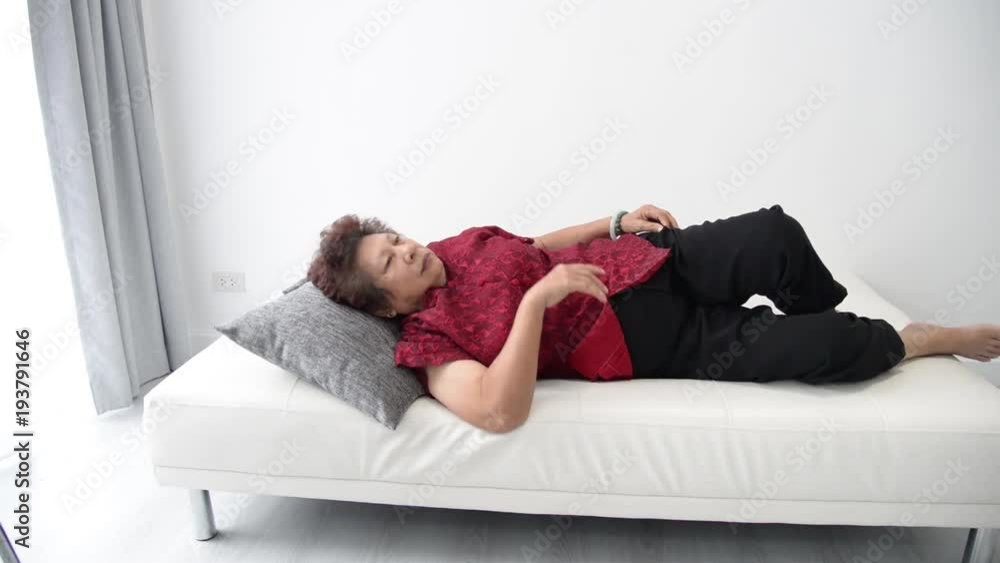 Senior woman sleeping on the couch at home in the living room Senior woman sleeping on the couch at home in the living room