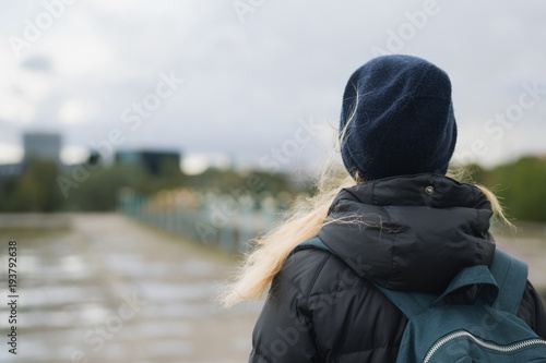 teen girl from behind walking in the city on a autumn day