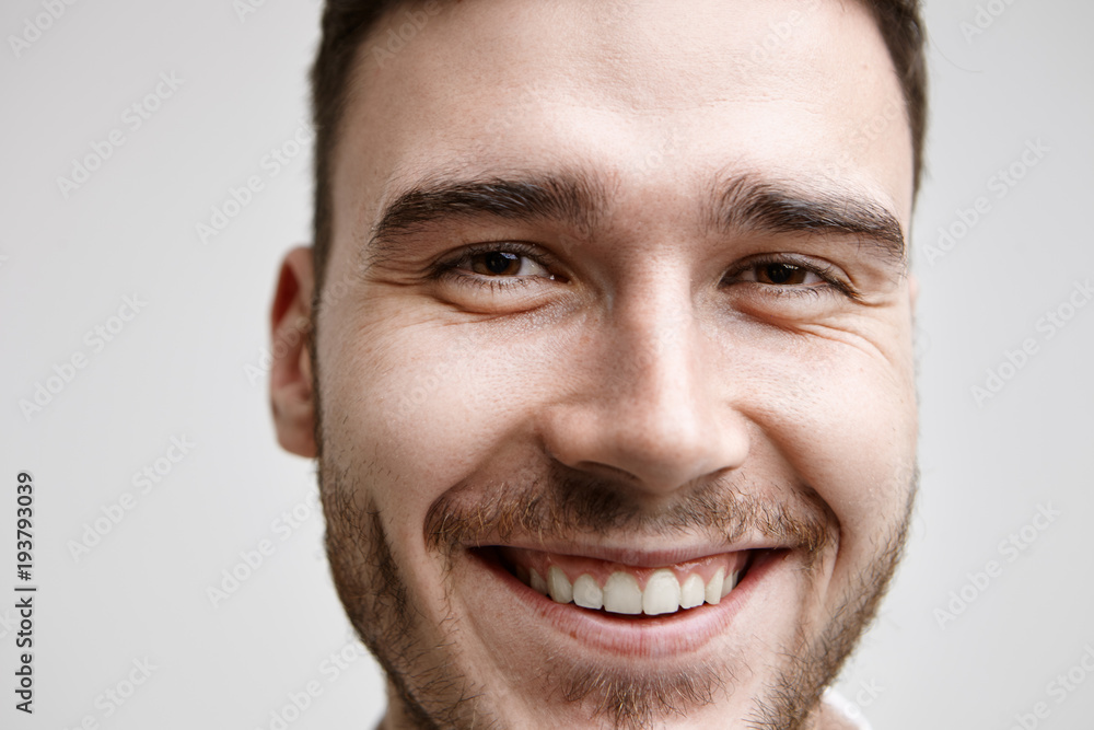 Fototapeta premium Positive human facial expressions, emotions and feelings. Isolated close up studio portrait of attractive cheerful young bearded man smiling broadly, feeling happy while receiving good news