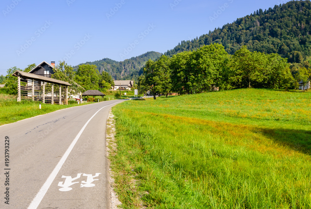 Pictorial field and an asphalt road on the background of mountain peaks, Bled, Slovenia.
