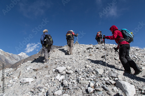 Wanderer überqueren den Ngozumba Gletscher im Himalaya auf dem Weg zum Cho La Pass, Everestgebiet, Nepal photo