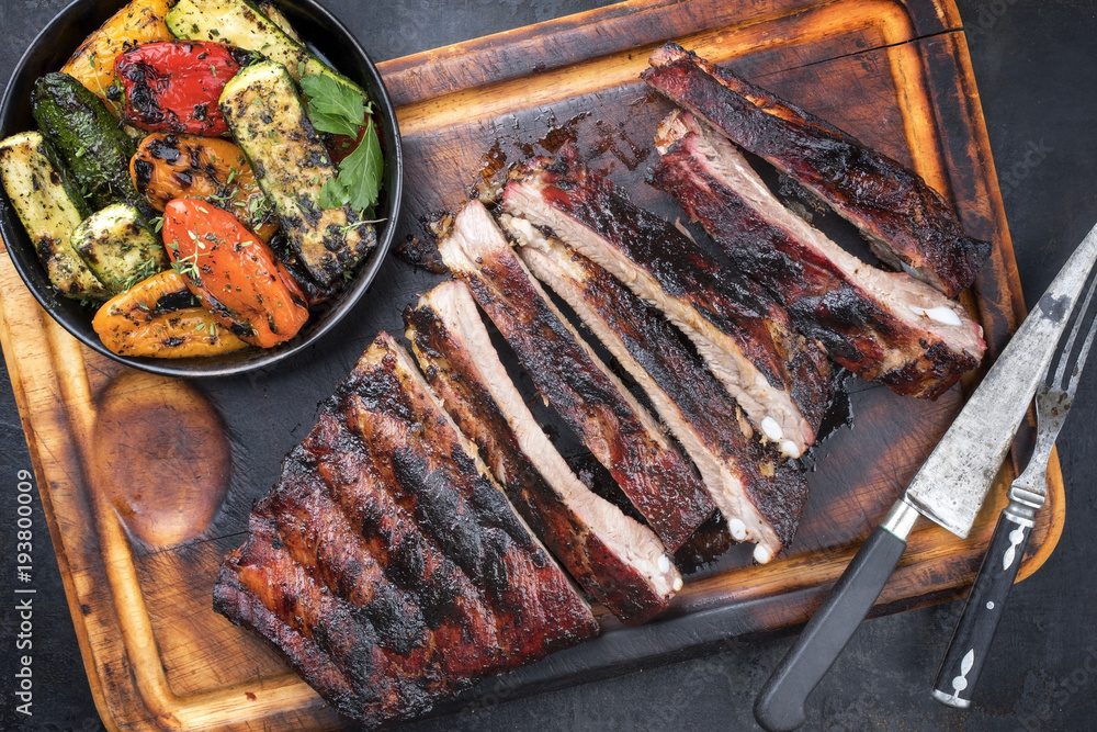 Barbecue spare ribs St Louis cut with hot honey chili marinade sliced as top view on an old rustic board Barbecue spare ribs St Louis cut with hot honey chili marinade sliced as top view on an old rustic board