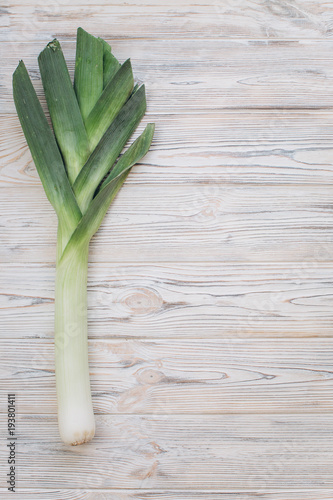 Leek onion on the wooden table. Top view and flat lay.