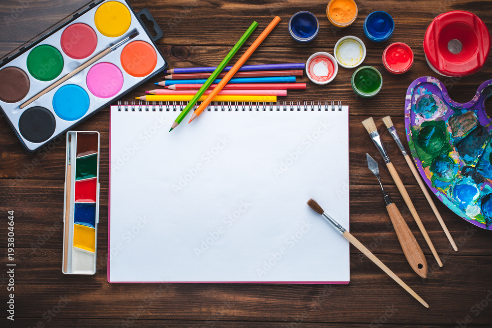 Fototapeta premium Set of paints, pencils, tools for painting and blank white paper sheet