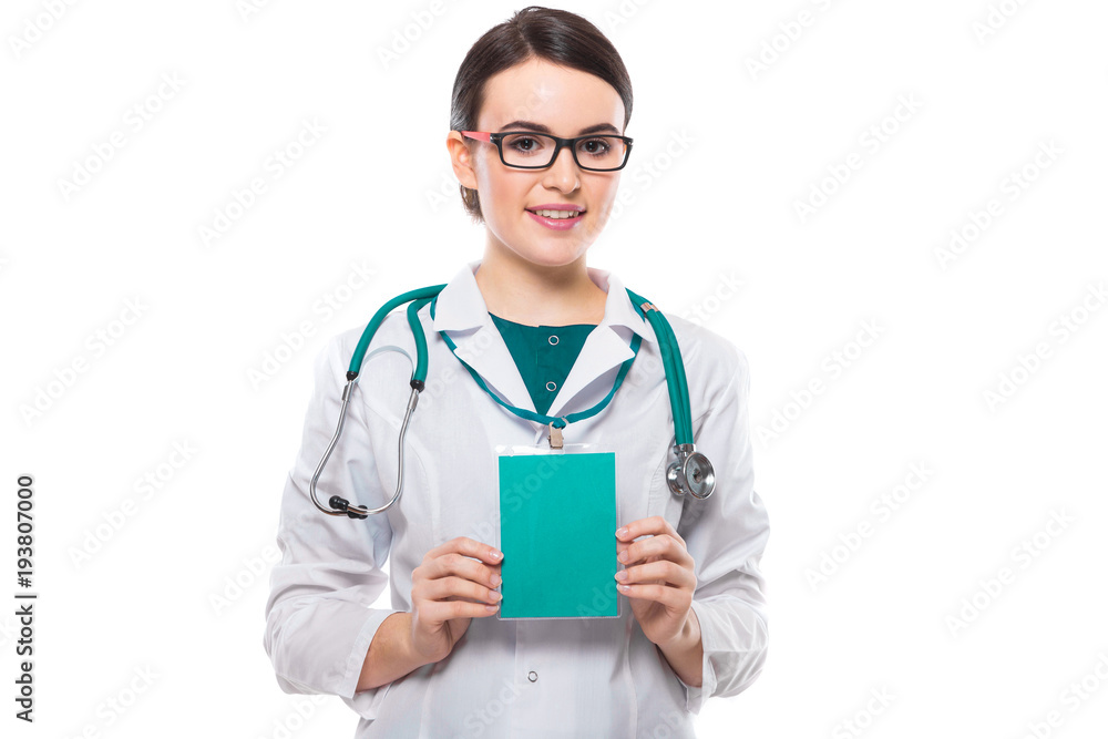 Young woman doctor with stethoscope holding green badge in her hands in white uniform on white background Young woman doctor with stethoscope holding green badge in her hands in white uniform on white background