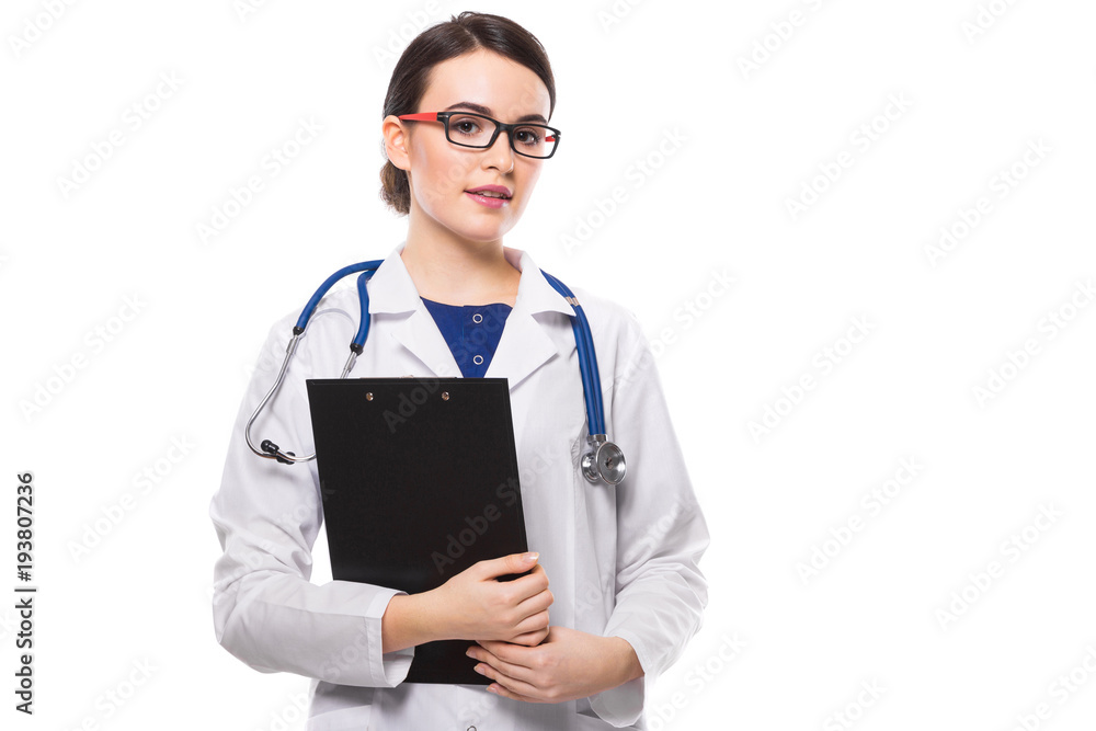 Young woman doctor with stethoscope holding clipboard with her hands in white uniform on white background Young woman doctor with stethoscope holding clipboard with her hands in white uniform on white background