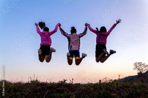 Group young girls jumping playing at sunset time.