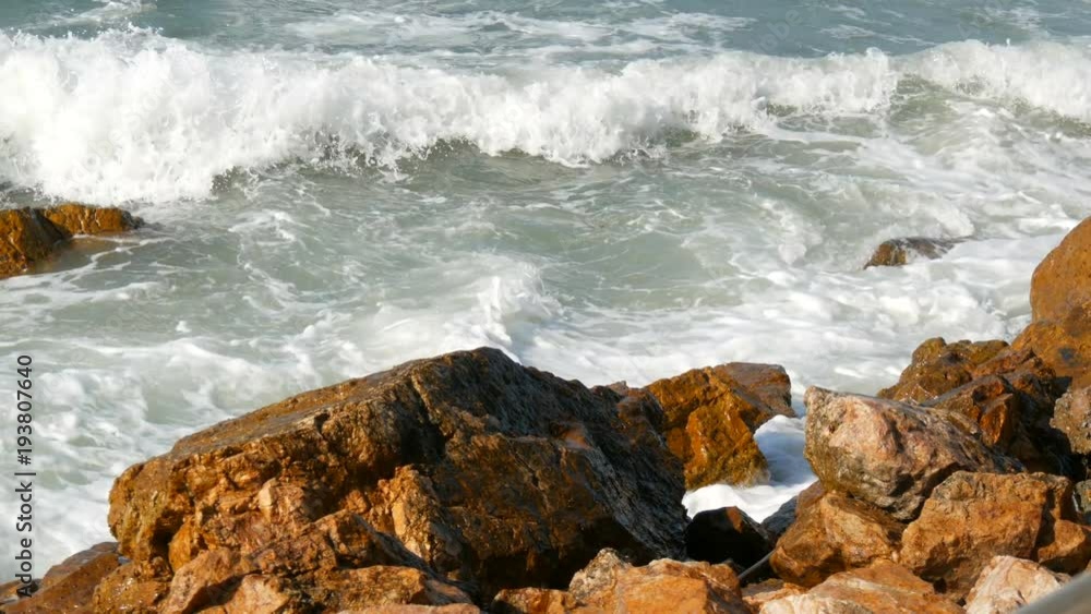 Waves beat against the rocky shore. Beautiful waves of the South China Sea close up view