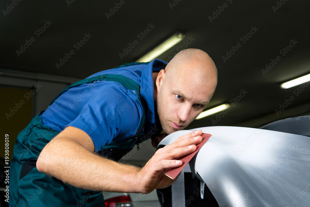 Φωτογραφία Grinder paper in the hands of a man who sharpen a car varnish in the car shop