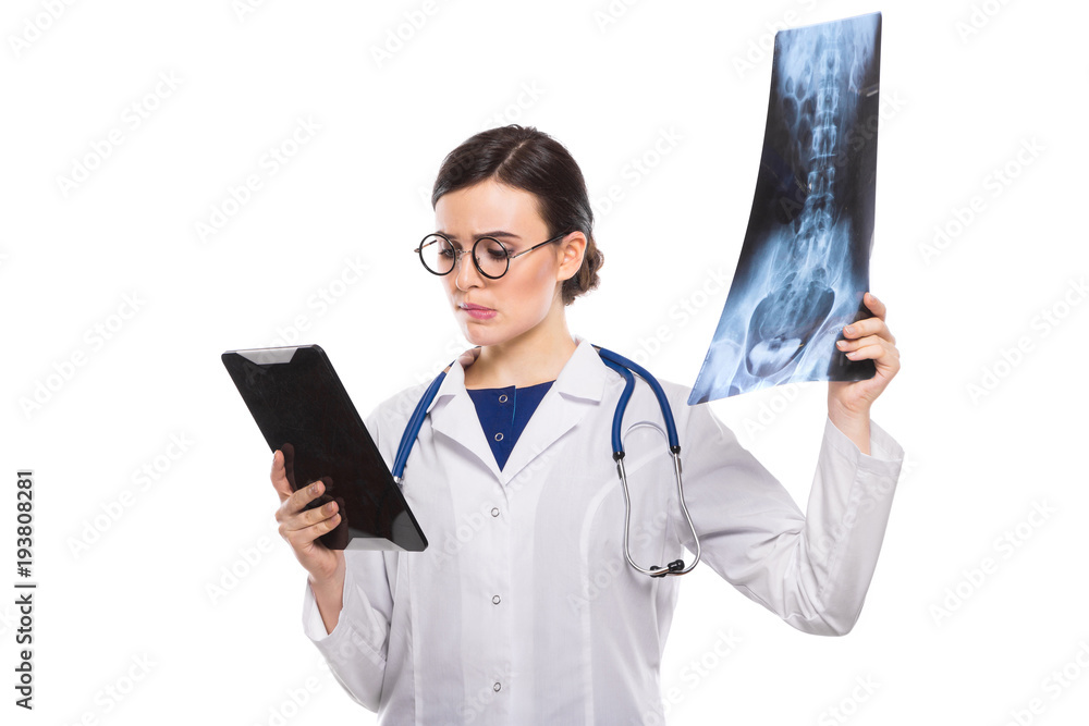 Young woman doctor with stethoscope looking at x-ray making diagnosis in white uniform on white background Young woman doctor with stethoscope looking at x-ray making diagnosis in white uniform on white background