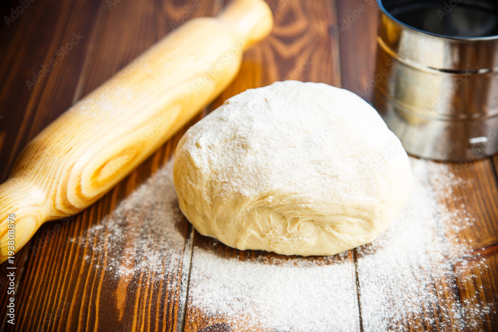 fresh raw dough with a rolling pin fresh raw dough with a rolling pin