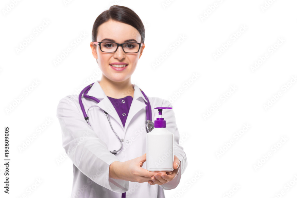 Young woman doctor with stethoscope offering antiseptic in white uniform on white background Young woman doctor with stethoscope offering antiseptic in white uniform on white background