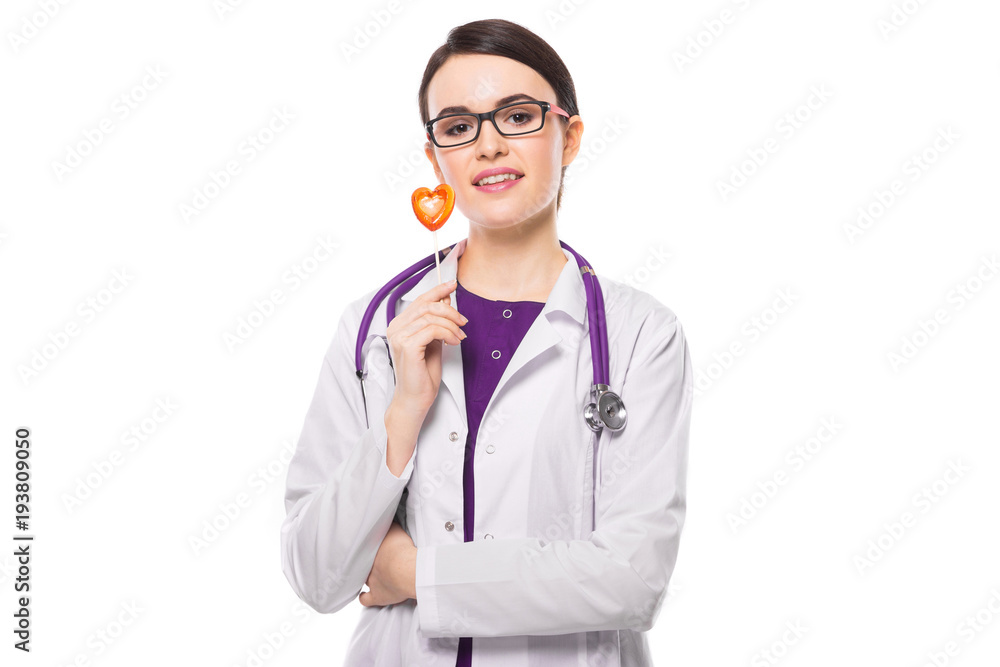 Young woman doctor with stethoscope holding heart in her hands in white uniform on white background Young woman doctor with stethoscope holding heart in her hands in white uniform on white background