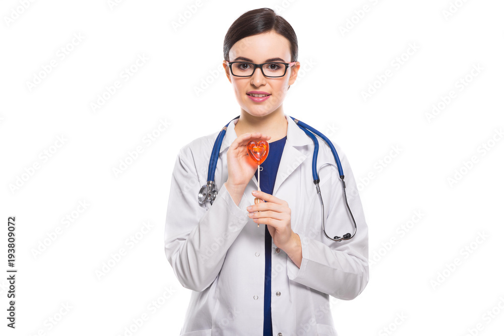 Young woman doctor with stethoscope protecting heart with her hands in white uniform on white background