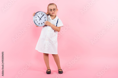 Little girl in doctor costume with clocks