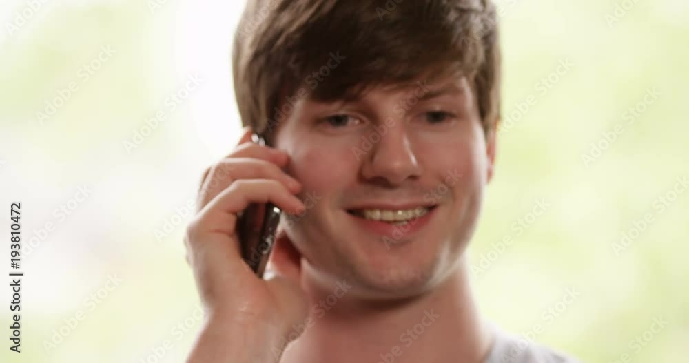 4k, Young attractive man talking on his cellphone at home. 4k, Young attractive man talking on his cellphone at home.