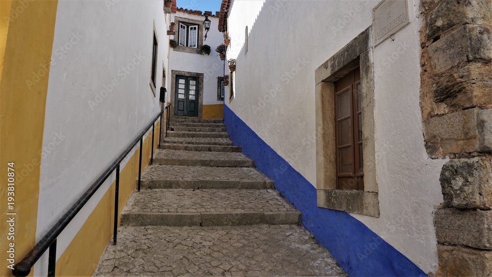 A colorful Street in the medieval town of Obidos, Portugal. Obidos is a city with history and culture. It combines the middle ages and the present one. Photos filmed on 19.09.2015 year.