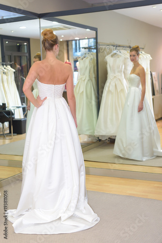 Woman admiring wedding dress in mirror