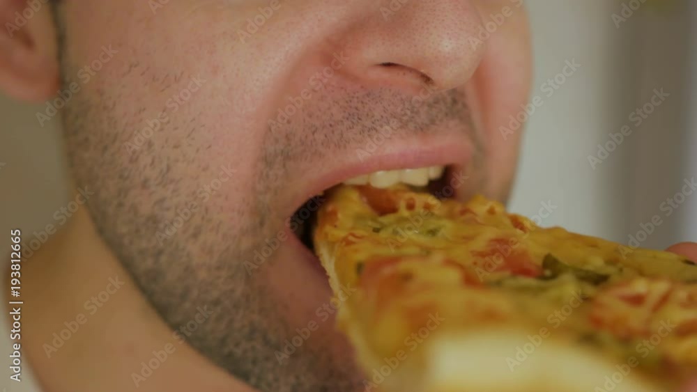 Caucasian man eating pizza. Hungry male taking a bite from pizza. Closeup. Caucasian man eating pizza. Hungry male taking a bite from pizza. Closeup.