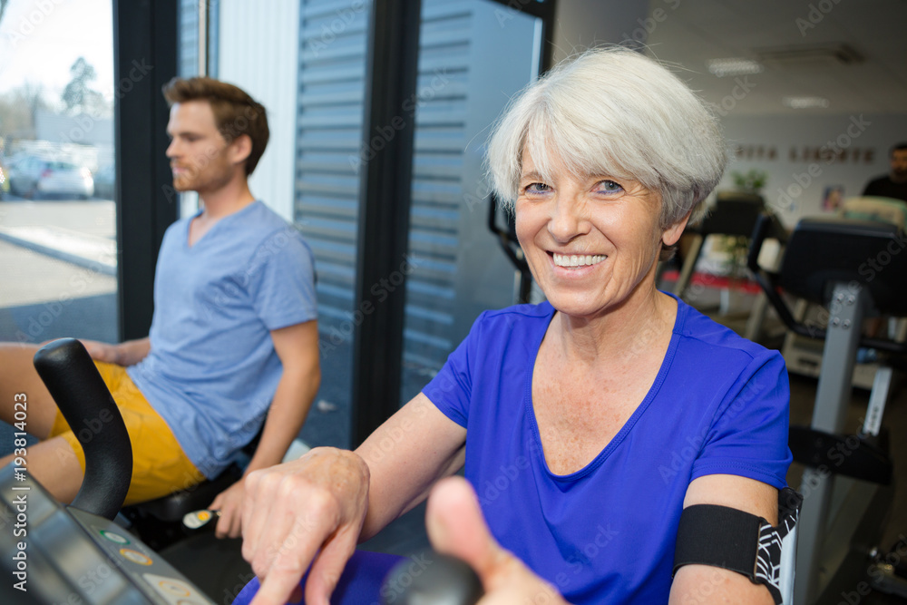 smiling female senior exercising in gym smiling female senior exercising in gym