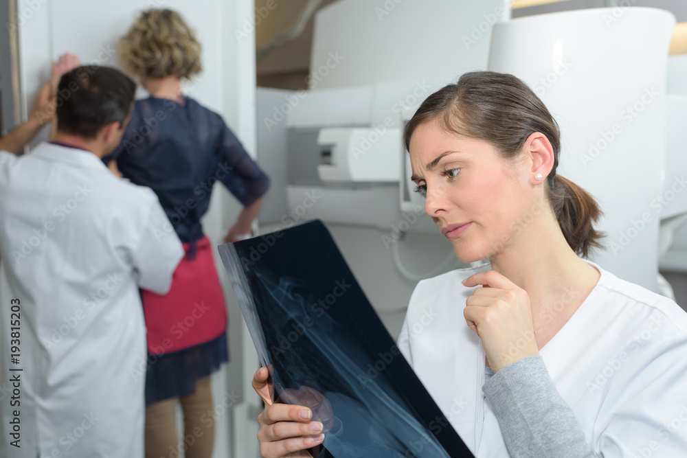 female doctor checking xray image being very concerned female doctor checking xray image being very concerned