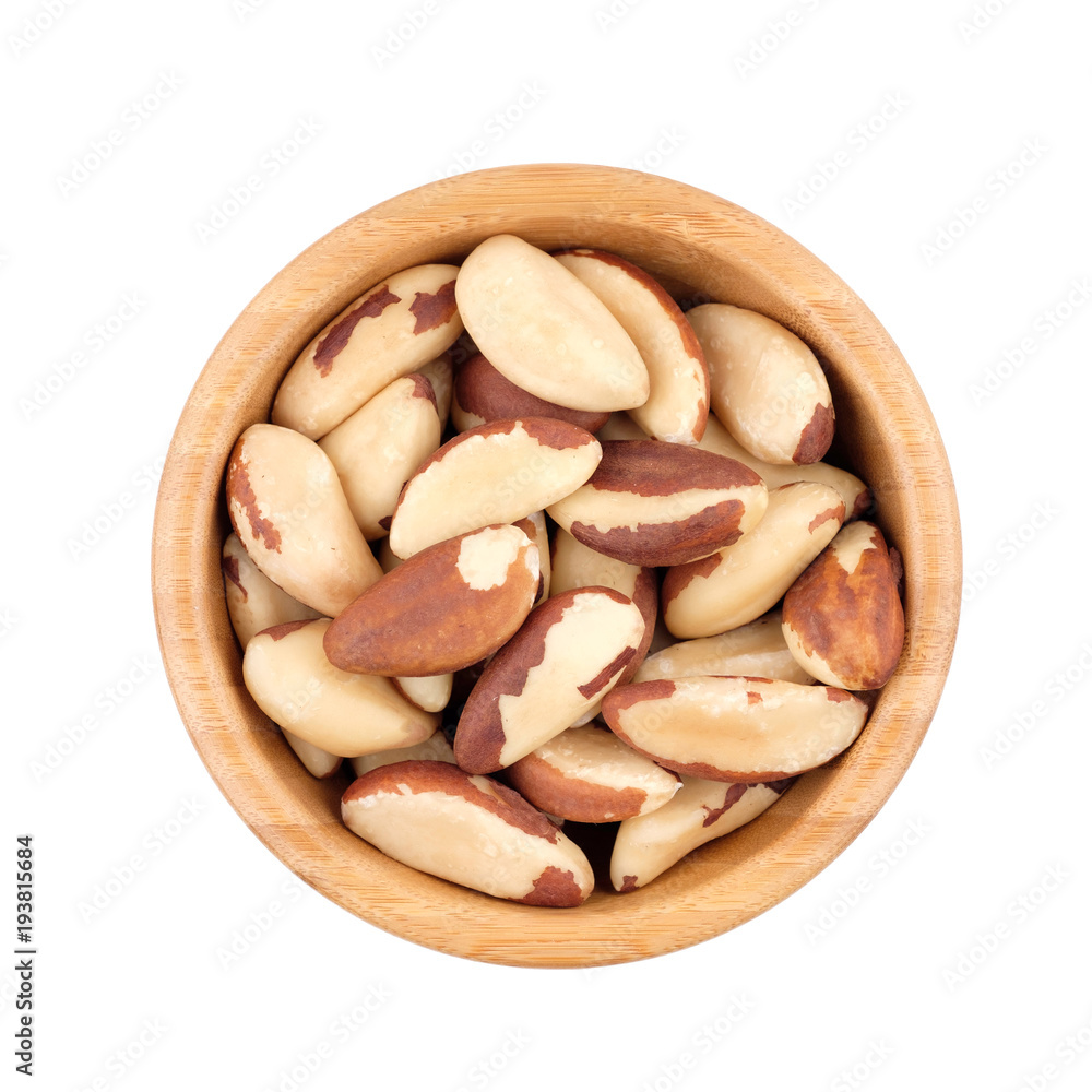 Fototapeta premium Brazil nut in wooden bowl isolated on white. Top view.