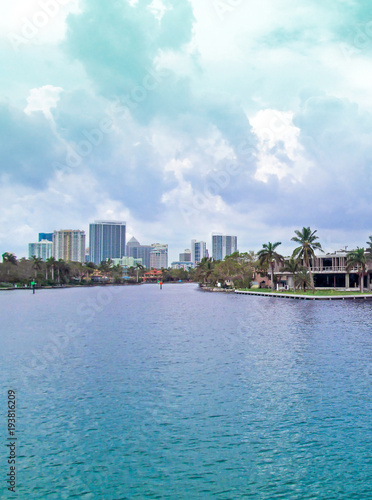 Canal of Fort Lauderdale, Florida, USA.  Panoramic view of downtown with luxurious estates, palm trees on the waterfront and boats on cloudy day.  © mivod