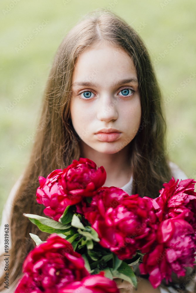 Tender sensitive girl with blue eyes on a picnic with sweet creamy cheesecake with peonies Tender sensitive girl with blue eyes on a picnic with sweet creamy cheesecake with peonies
