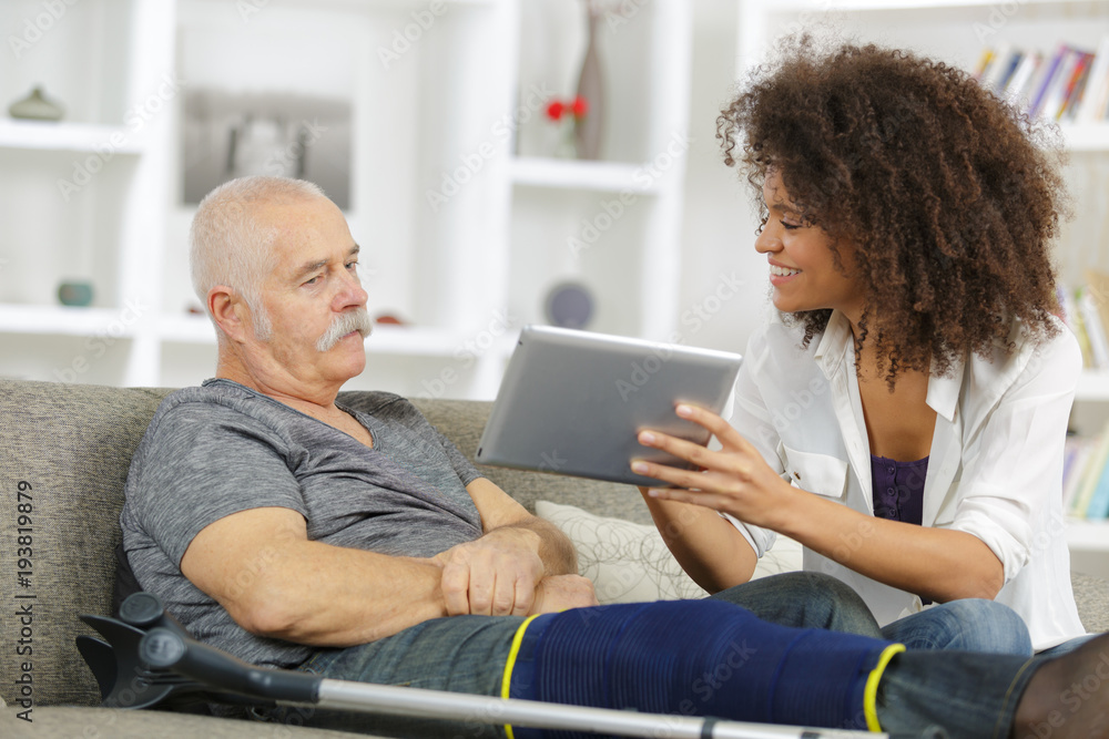 home help woman helping seniro man in wheelchair home help woman helping seniro man in wheelchair