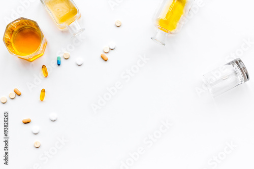 Alocohol abuse and alcoholism treatment concept. Glasses, bottles and medcine pills on white background top view copy space photo