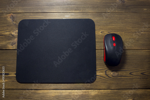 Computer mouse pad and mouse on a wooden background
