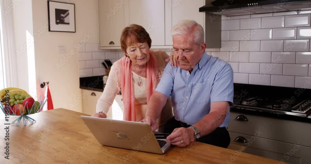 4k, Senior couple browsing the internet on their laptop from home. Slow motion. 4k, Senior couple browsing the internet on their laptop from home. Slow motion.