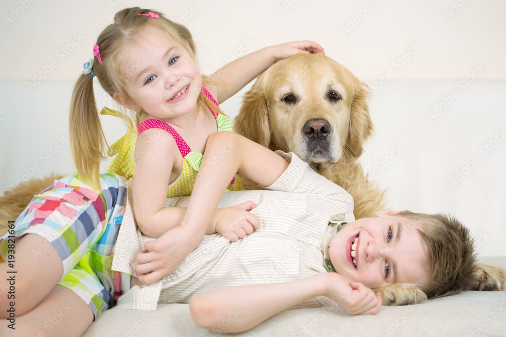 Cute Happy Kids Playing With Golden Retriever Dog On Bed Cute Happy Kids Playing With Golden Retriever Dog On Bed