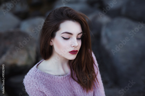 Beautiful young woman. Dramatic outdoor portrait of sensual brunette female with long hair. Sad and serious girl.