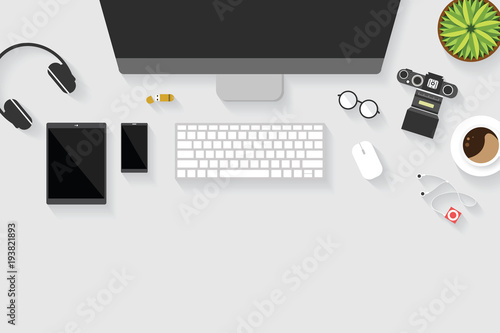 Top view of table working and working desk with gadget and free space for text with accessory on the table, desktop, keyboard, camera, flowerpot, glasses, earphone, mouse, coffee cup