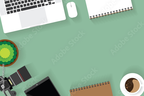 Top view of table working and working desk with gadget and free space for text with accessory on the table, camera, note, phone, coffee cup, flowerpot, laptop
