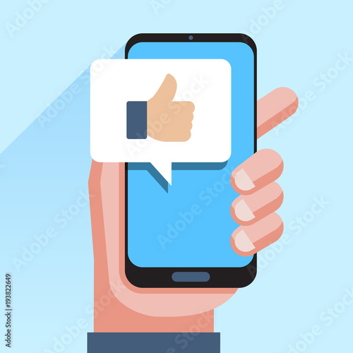 Hand holding smartphone with like message on screen, like button. Thumbs up icon.