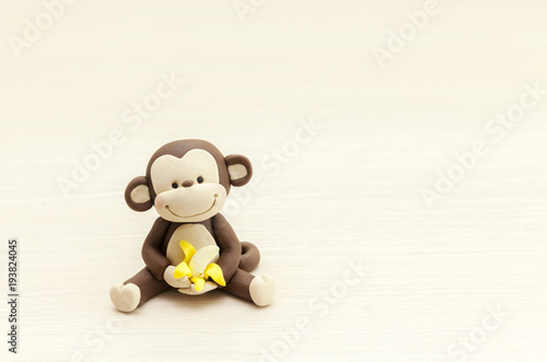 little monkey toy sitting with a banana