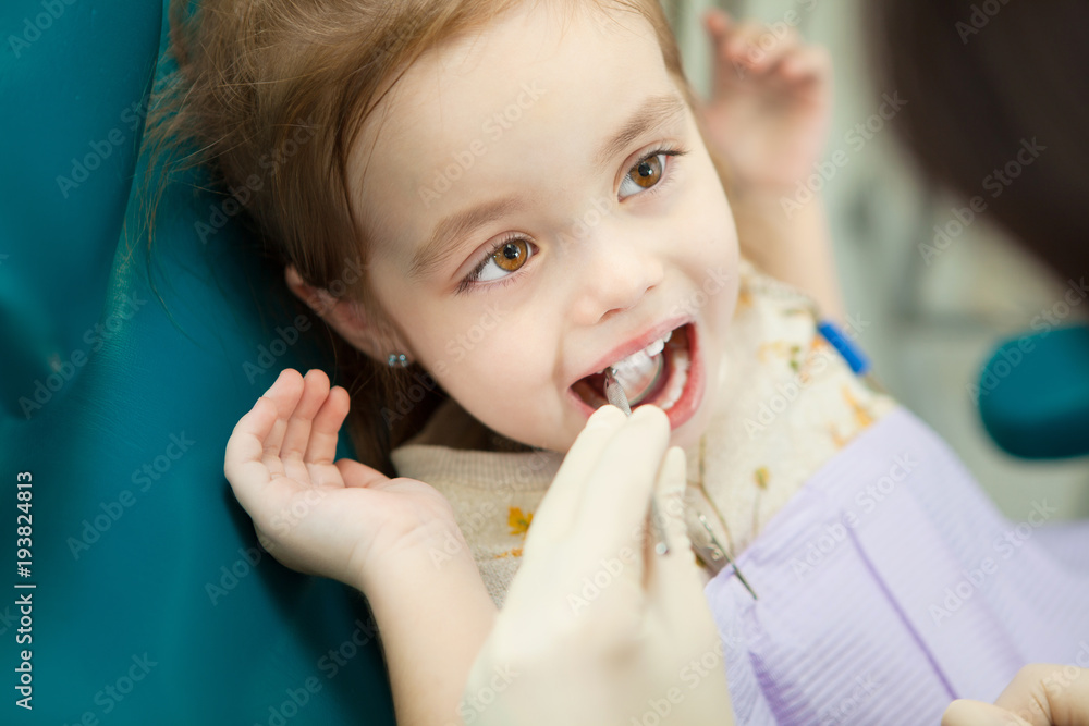 Child lies in dentist chair and doctor does checkup Child lies in dentist chair and doctor does checkup
