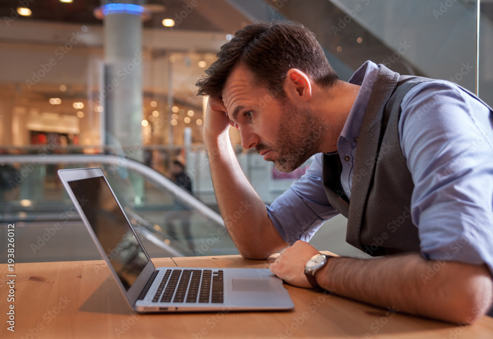 Stressed man using laptop, crisis in business Stressed man using laptop, crisis in business