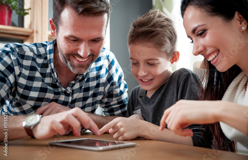 Happy family using tablet together at home